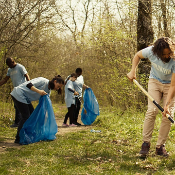 People participating in a community cleanup event in a forested area.